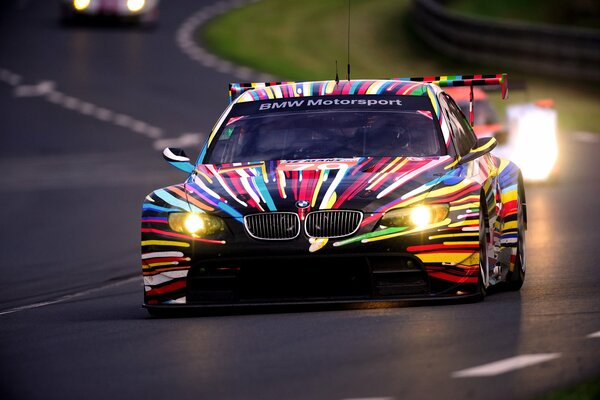 BMW sportiva con colorazione multicolore, in pista