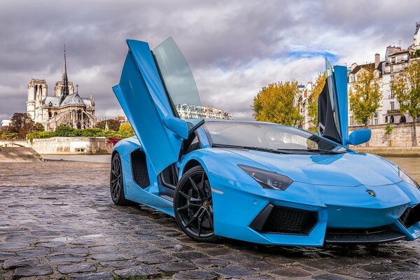 Голубая lamborghini с открытыми дверями в париже