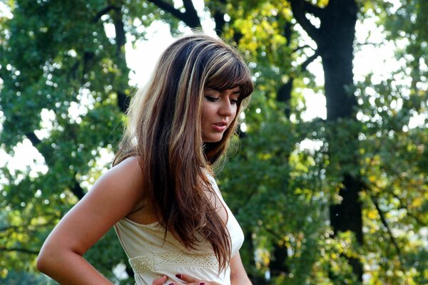 Chica con el pelo largo en el fondo de los árboles en el bosque