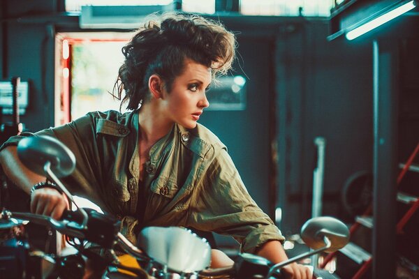 Beautiful biker on a cool motorcycle in the garage