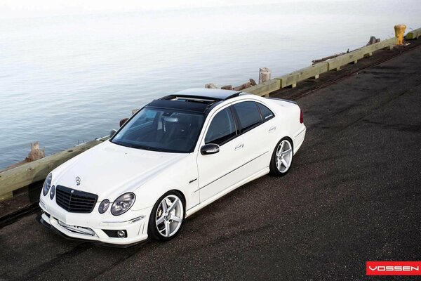 Mercedes blanco en la carretera junto al mar