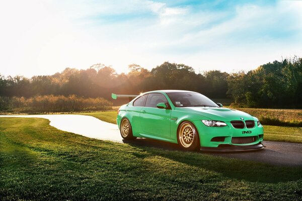 BMW verde en la carretera solar