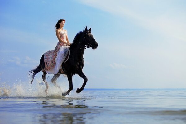 A brown-haired woman on a horse jumps on the sea