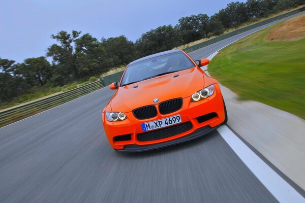 Une BMW orange roule sur la route