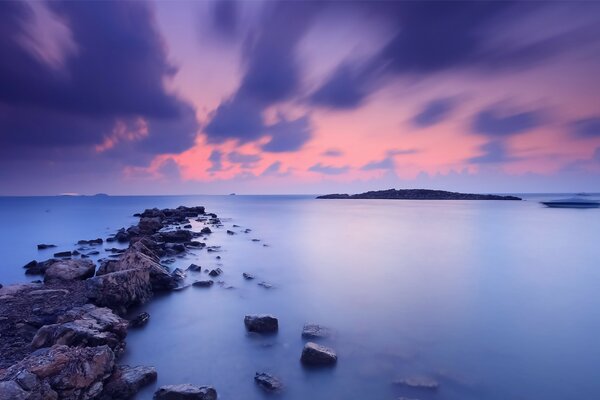 Rocks in the sea on the background of an orange sunset