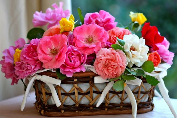 Bunte Blumen in einem Korb mit weißen Bögen