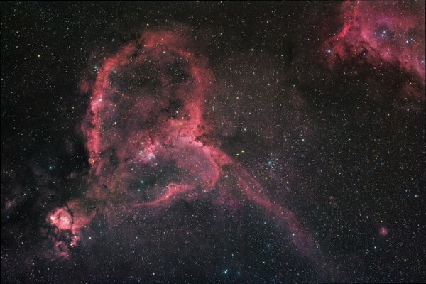 Nebulosas rojas contra un cielo lleno de estrellas