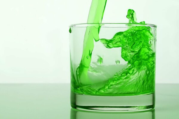 Bebida energética de color verde vertida efectivamente en un vaso