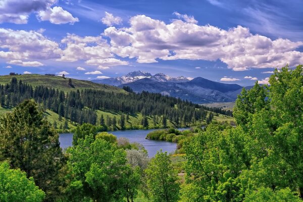 A VALLEY WITH A LAKE AT THE FOOT OF THE MOUNTAINS