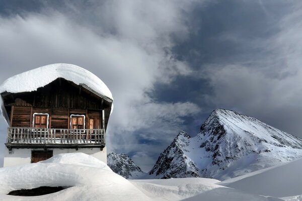 Ein Haus in den Bergen. Schnee. die Berge