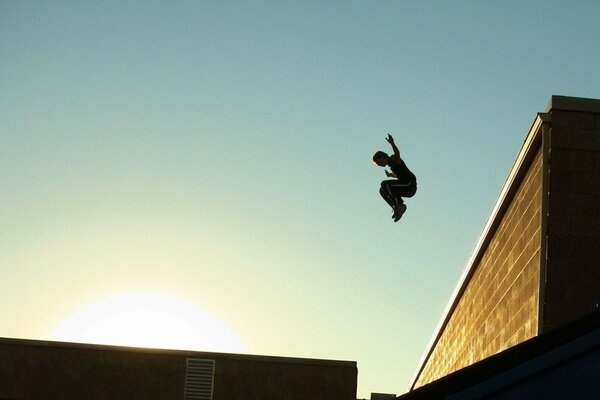 A man jumping from the roof in the sunlight