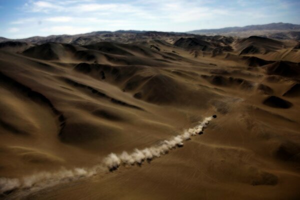 A column of dust from a car in the desert