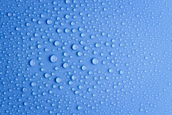 Water drops on a blue background under a macro