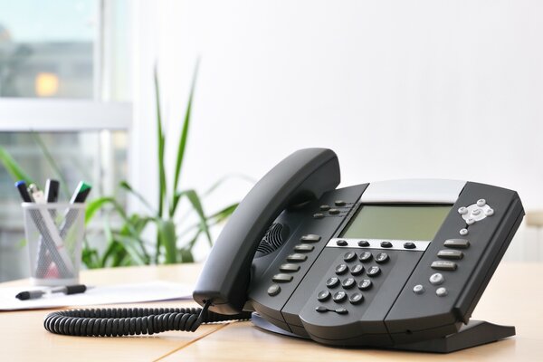 Das Telefon auf dem Schreibtisch im Büro auswerfen