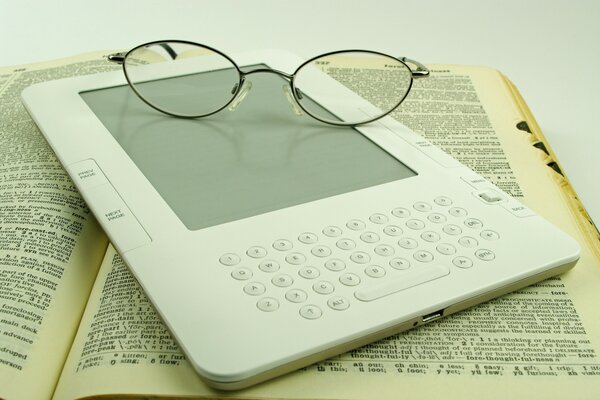 Las gafas se encuentran en un libro electrónico y ordinario