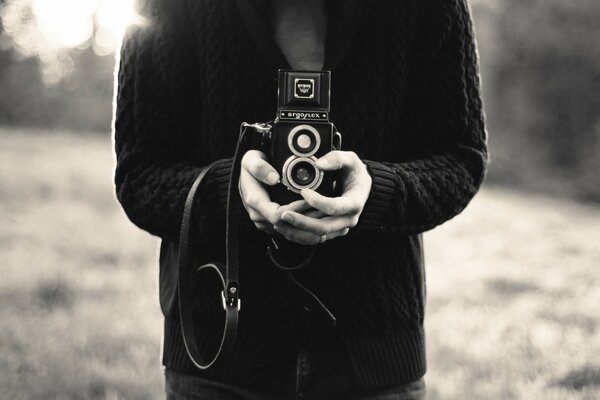 Black and white image of hands with a camera