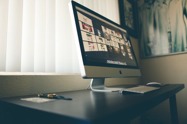 Ein Tisch mit einem Imac, der darauf steht