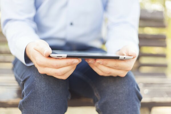 Homme avec tablette sur le banc dans le parc