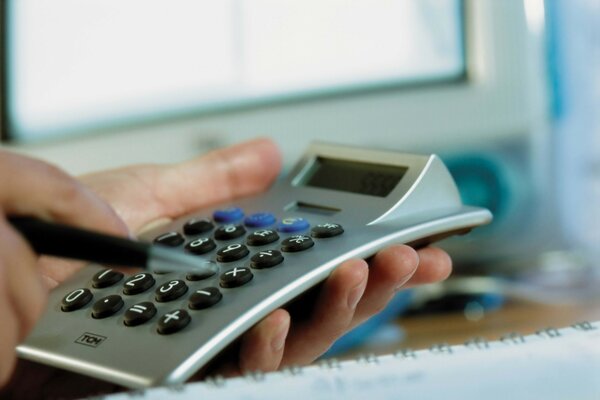 Calculator and hand with pen