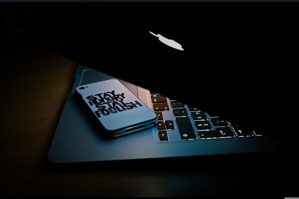 A laptop keyboard and a Steve Jobs phone