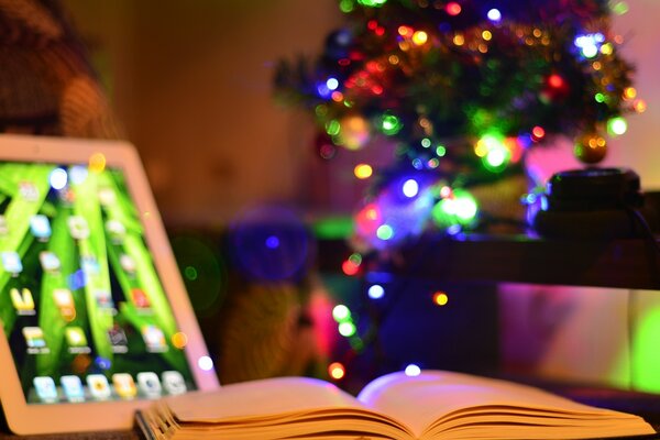 Libro aperto e iPad su, sfondo dell albero di Natale