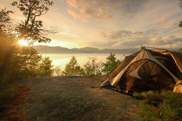 Tent on the shore of the lake at sunset