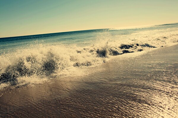 Waves are beating on the sandy shore