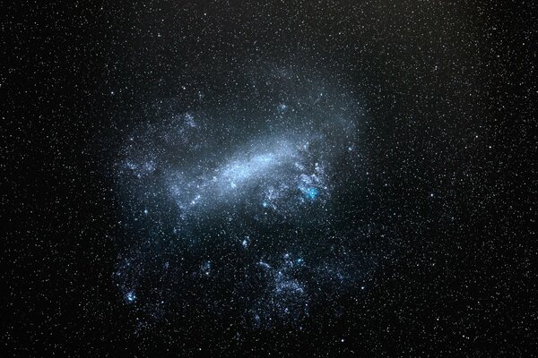 Cielo en el espacio noche con grandes nubes de magelan, brillan las estrellas