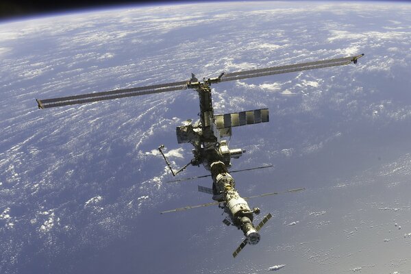 View of the orbital station from space against the background of the earth