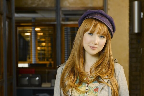 Red-haired beautiful girl in a lilac cap