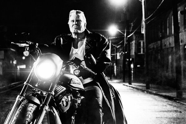 Mickey Rourke sur une moto en fond noir et blanc