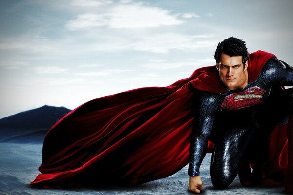 A superhero in a red cape in the desert