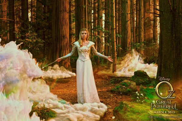 A girl in a dress is standing in the forest