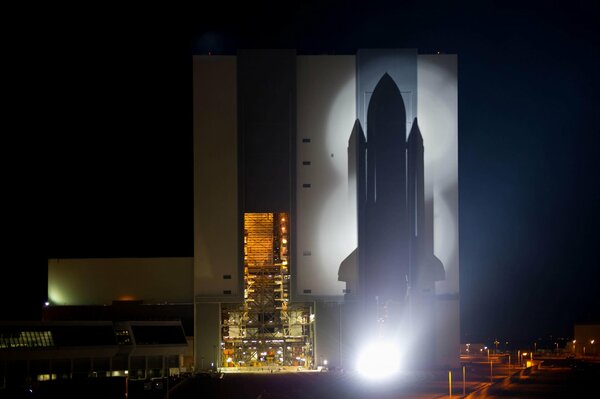 The silhouette of the space shuttle with the background of the night city