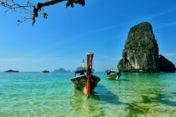 Boats near the cliff. Clean water