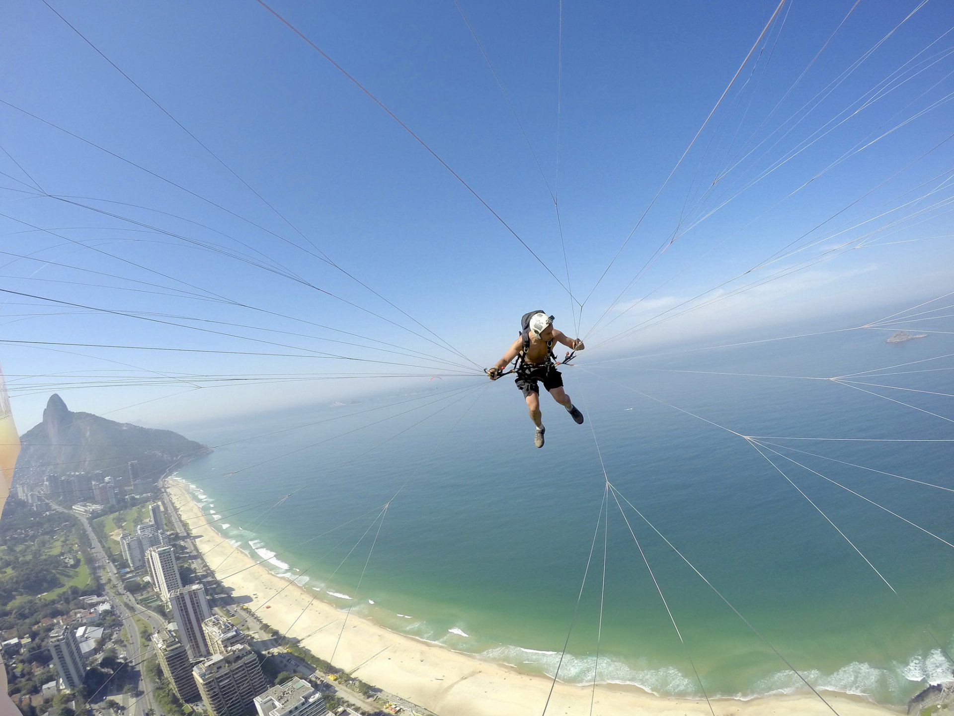 parapendio parapendio pilota macchina fotografica casco filo spiaggia mare isolotto orizzonte cielo brasile rio de janeiro sport estremi