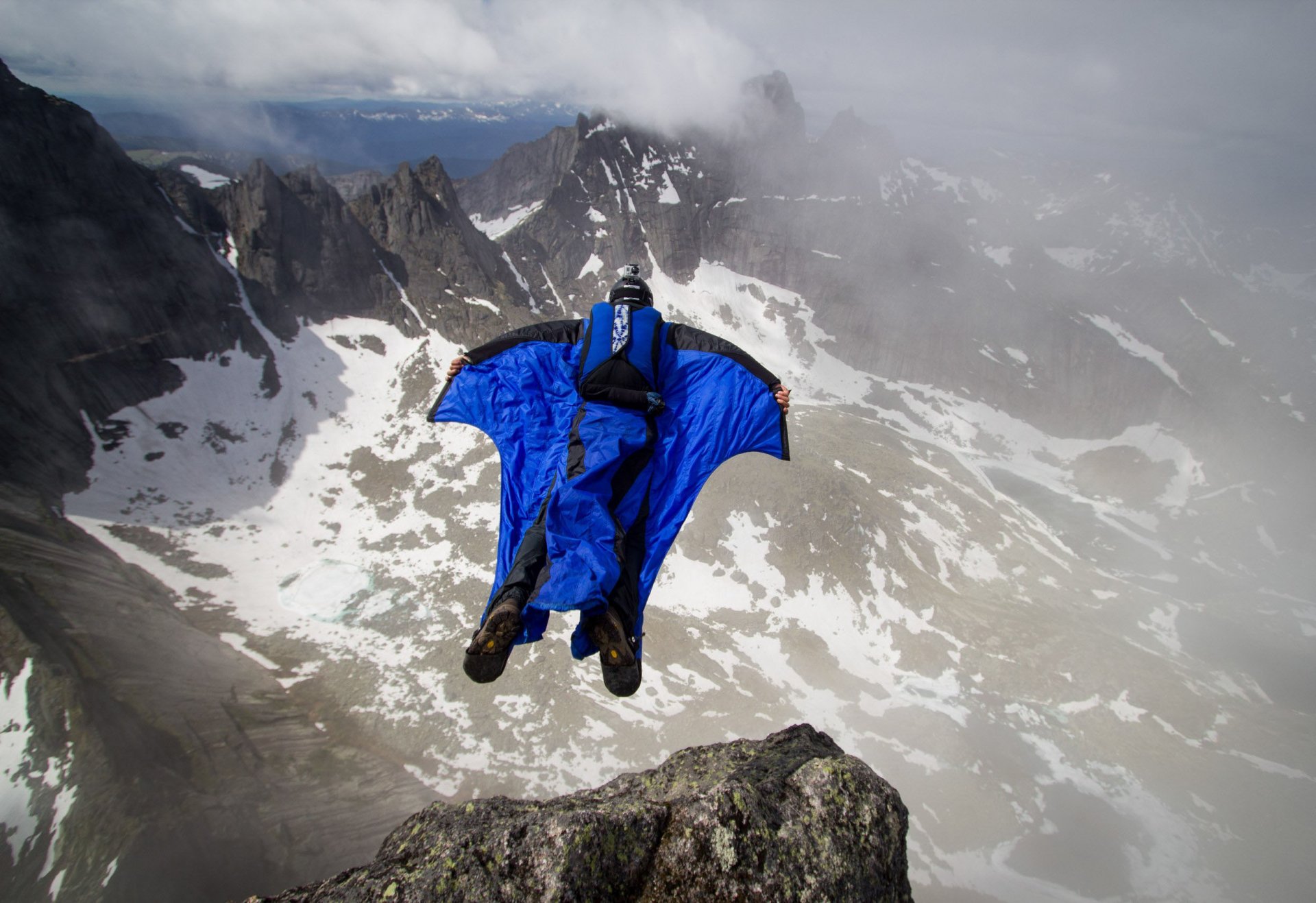 tuta alare pilota base jumping baser montagne rocce nuvole contenitore paracadute sport estremi