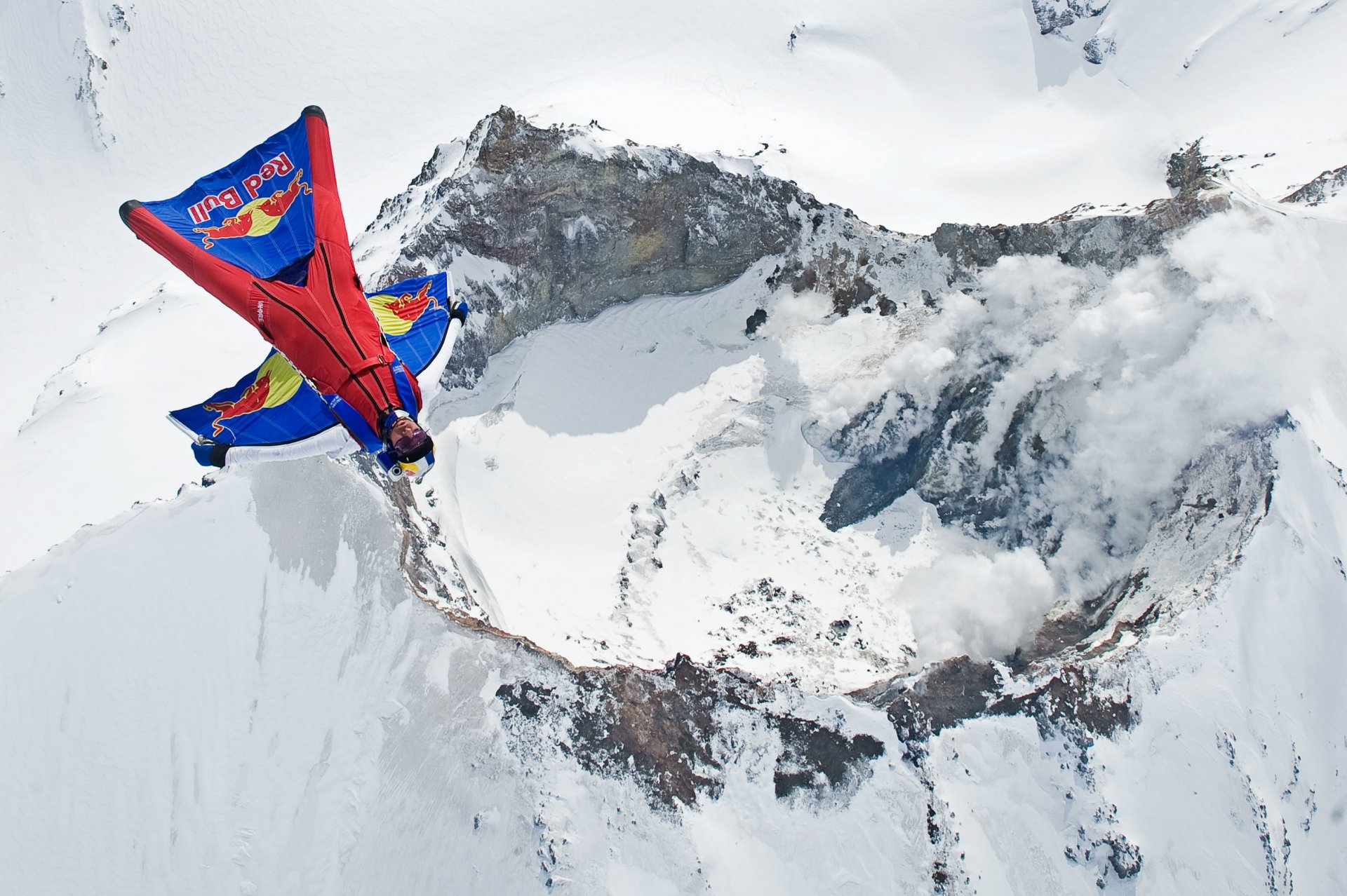 traje de alas piloto volar piloto volcán montaña humo nieve invierno contenedor paracaídas toro rojo deportes extremos