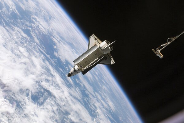 La navette spatiale de la NASA plane dans l espace sur le fond de la terre
