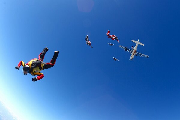 Paracaidistas flotando en el cielo azul