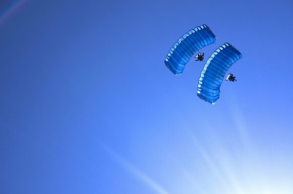 Zwei Fallschirmspringer am blauen Himmel