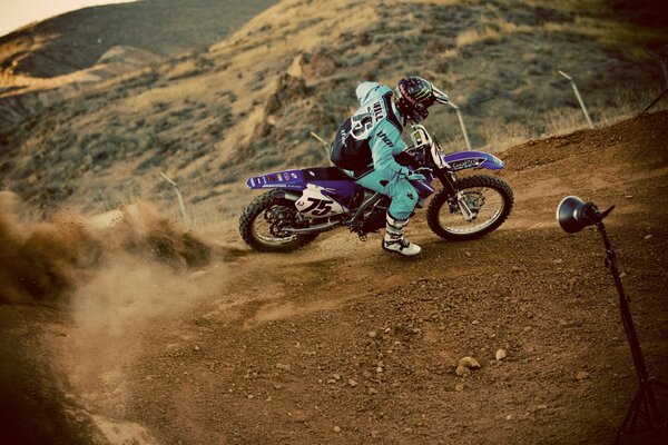 Motorcycle U-turn on the road with dust