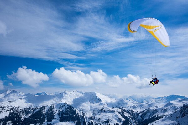 Un parapente vuela sobre picos nevados