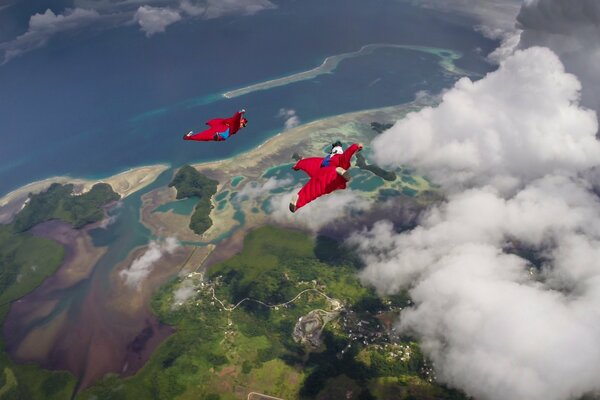 Parachutists flying over the sea and clouds