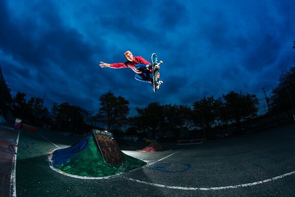 Saut en hauteur sur une planche à roulettes sur fond de ciel nocturne