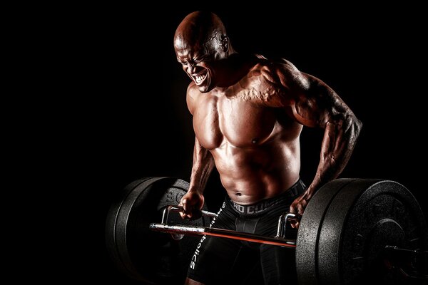 A bodybuilder is engaged with a heavy barbell