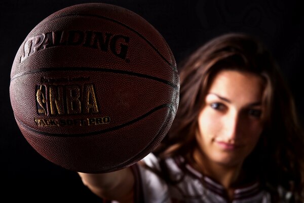 A girl shows a basketball