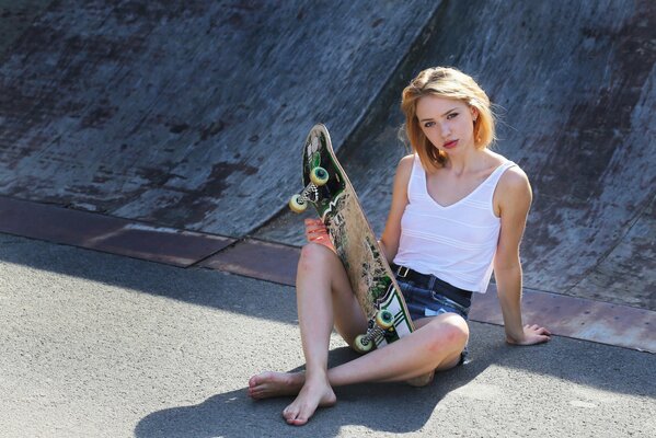 Chica sentada en una pista de patinaje