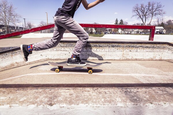 A skateboarder rides a board from a slope