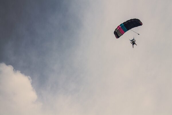 Blick von unten auf den Fallschirmspringer in den Wolken